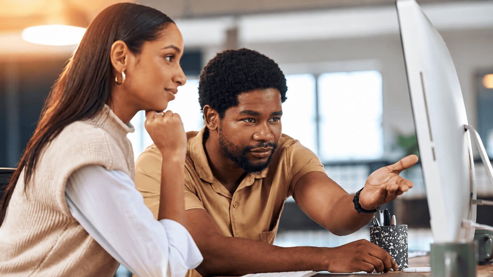 Two founders reviewing figures together on a desktop screen